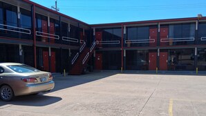 A building with a parking lot, a staircase, and a car. - Coratel Inn and Suites By Jasper Anthony (Anthony)