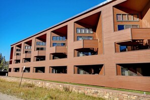 Un edificio de varios pisos con fachada de madera y varios balcones.