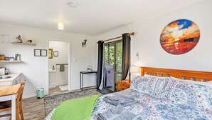 Ein Schlafzimmer mit Bett, Schreibtisch und Bad.