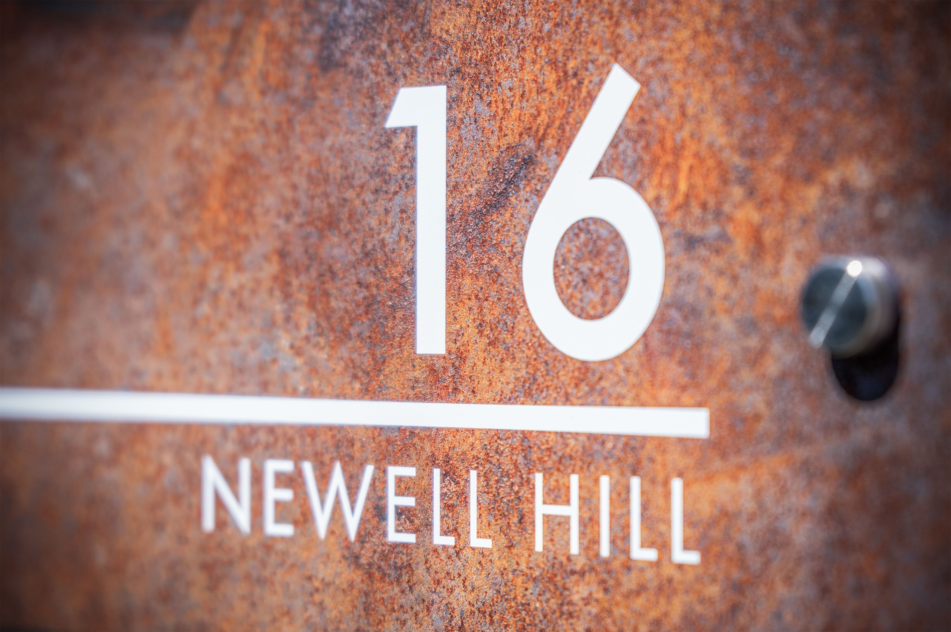 Ein Detailbild eines Schildes mit der Nummer 16 und dem Text 'NEWELL HILL'.