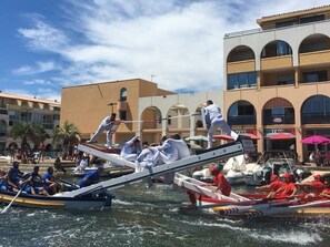 Una carrera de botes con participantes vestidos con uniformes blancos y rojos.