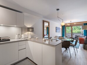 Relax in a spacious room with a central island, perfect for dining and working, and a cozy seating area with a sofa and armchairs.