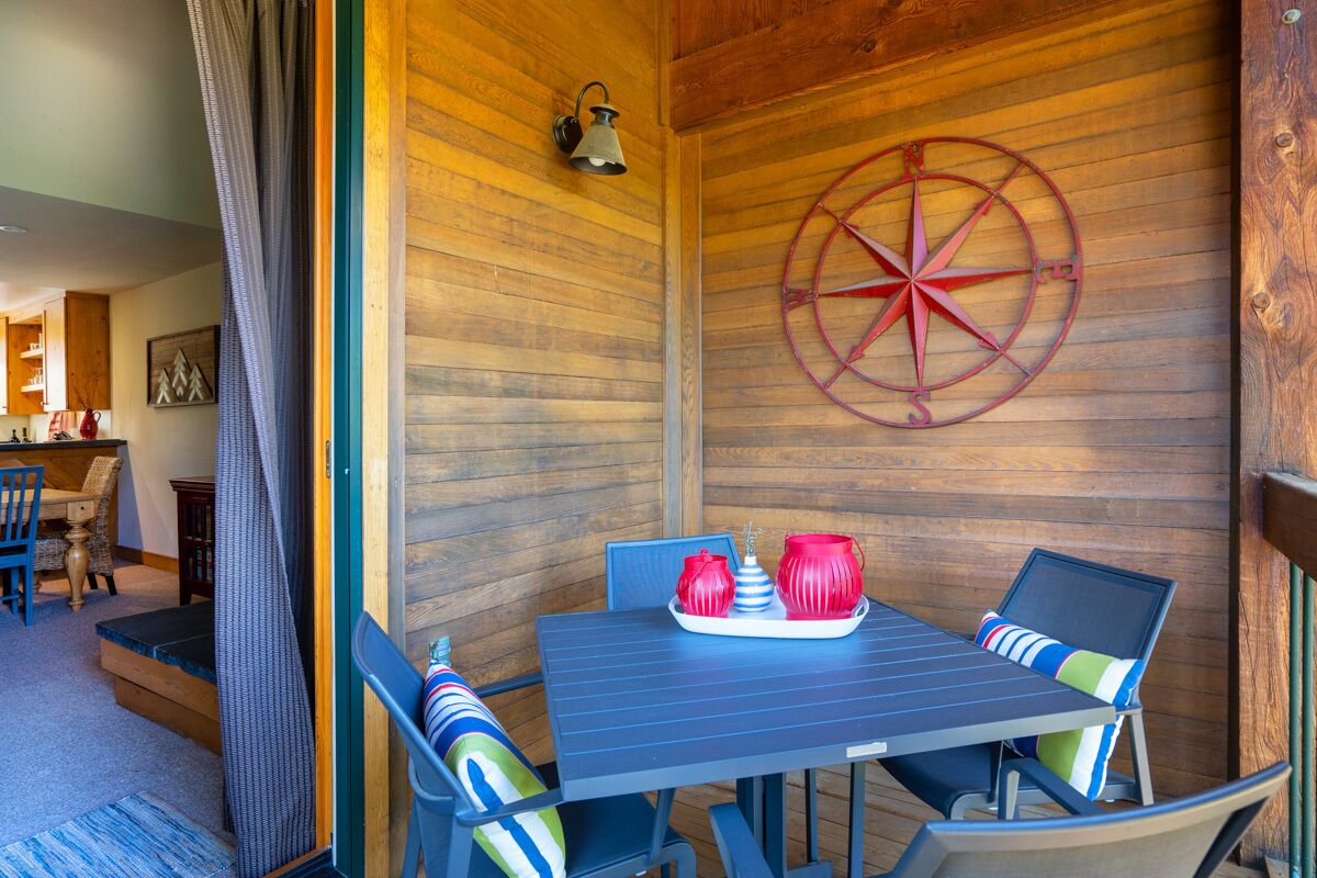 Un espace repas avec un mur en bois, une décoration sur le thème de la boussole et une table entourée de chaises.