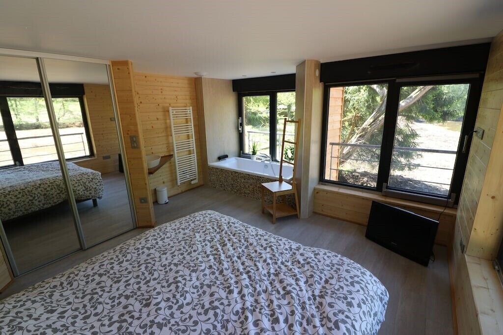 A bedroom with a bed, a window, a chair, and a small table.