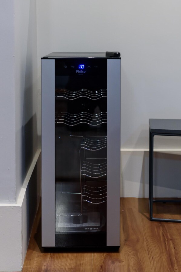 A compact, modern refrigerator with a digital display, located in a corner of a room with wooden flooring and a plain wall. - 1 Minute From Ipanema Beach Vsc3 (Rio de Janeiro)