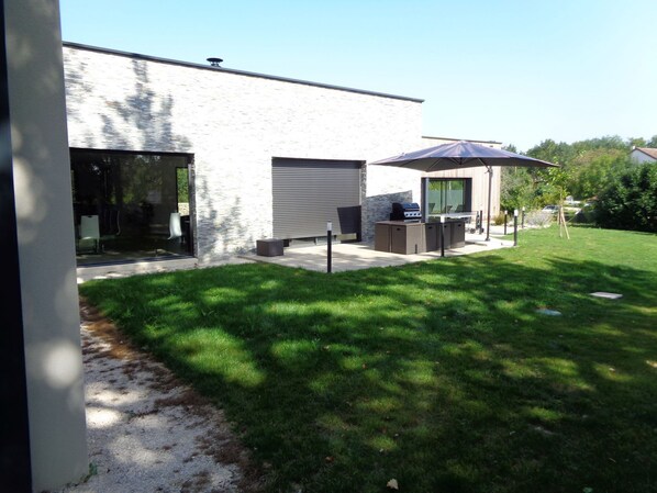 Enjoy al fresco dining and relaxation in this serene outdoor patio area with a barbecue grill and comfortable seating.