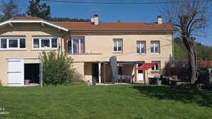 A two-story house with a beige exterior, a red-tiled roof, and a covered patio area. - Un Lieu Bucolique, Idéal Pour se Ressourcer (Beauzac)