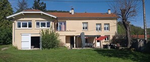 A two-story house with a beige exterior, a red-tiled roof, and a covered patio area. - Un Lieu Bucolique, Idéal Pour se Ressourcer (Beauzac)