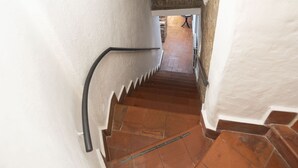 A narrow staircase with white walls and terracotta tiles. - Campo de Fiori Grotto Apartment (Roma)