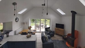 Una sala de estar moderna con sofá, televisión y chimenea.