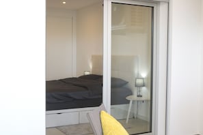 Une chambre à coucher moderne avec un lit, une table de chevet et une lampe.