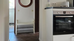 Una cucina con forno integrato e forno a microonde sul piano di lavoro.