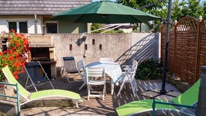 An outdoor patio with a barbecue grill, a table with chairs, and a green umbrella. - Homerez - House in Berrwiller (Berrwiller)