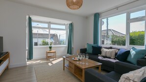 Un salon moderne avec un canapé, une table basse et une vue sur l’extérieur.