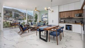 A modern kitchen with white cabinets, a wooden countertop, and a built-in oven. - CASA|AZUR – Distinctive Style with A View (Puerto Vallarta)