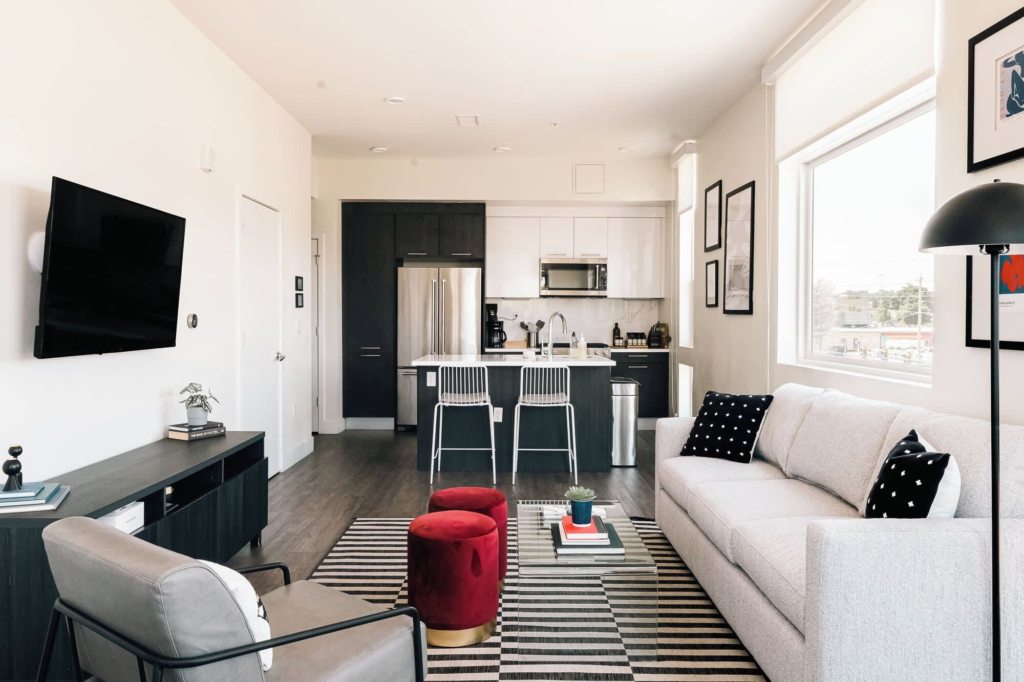 A modern apartment with a living room, a kitchen, and a dining area.