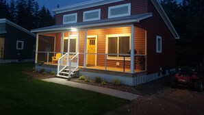 Ein zweigeschossiges Haus mit einer Veranda und einer Treppe, die zum Eingang führt.