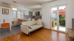 Eine moderne Wohnung mit Wohnzimmer, Essbereich, Küche und einem Balkon mit Blick.