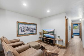 Una sala de estar con un sofá, un televisor y un cuadro en la pared.