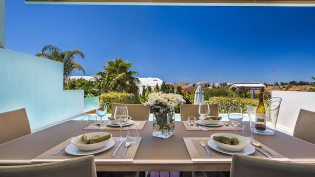 A dining table set for four with a clear view of the cityscape in the background.