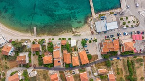 An aerial view of a coastal residential area with houses, a parking lot, and a beach. - Little House by the Sea, Beachfront, Parking, WiFi (Preko)