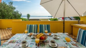 A breakfast table with a view of the sea, yellow walls, and striped cushions. - Little House by the Sea, Beachfront, Parking, WiFi (Preko)