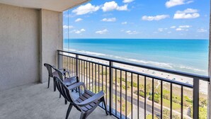 A balcony with two chairs overlooking a beach and ocean. - Ocean Forest Plaza Condos 🍹 Close to the beach 🍹 (Myrtle Beach)