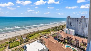A beachfront hotel with a pool, ocean view, and a high-rise building in the background. - Ocean Forest Plaza Condos 🍹 Close to the beach 🍹 (Myrtle Beach)