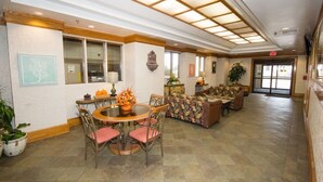 A spacious lobby with a round dining table, chairs, a sofa, and a coffee table.