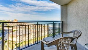 A balcony with a view of a cityscape and the sea.