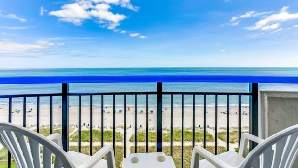 Uma varanda com vista para a praia e o oceano.