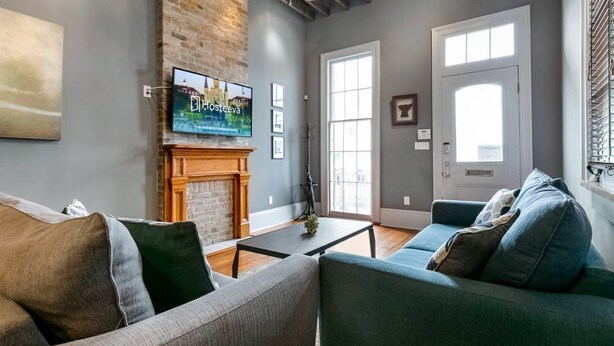 Una sala de estar con chimenea, televisor y un amplio ventanal.