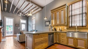 Una cocina moderna con armarios de madera, un lavamanos de acero inoxidable y una isla grande con lavavajillas.