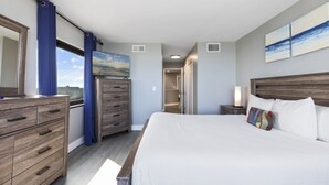 Un dormitorio con una cama grande, cómoda de madera y vistas al cielo a través de una ventana.