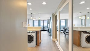 Un moderno cuarto de lavandería con lavadoras y secadoras integradas, un comedor con vistas y un corredor espacioso con luz natural.