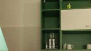 Una habitación con un armario verde, un escritorio blanco y una lámpara.