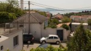 Un barrio residencial con casas, un automóvil y una vista distante de una torre.