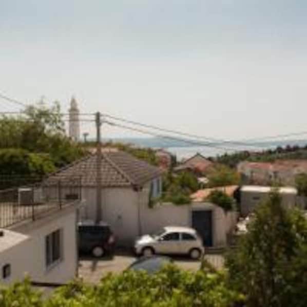 A residential area with houses, a car, and a distant view of a tower.