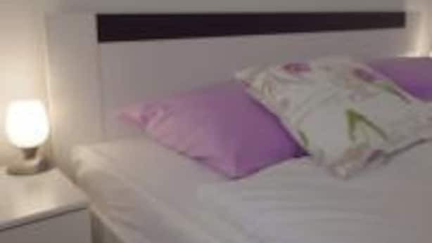 Un dormitorio con una cama individual, una mesita de noche y una lámpara de noche.