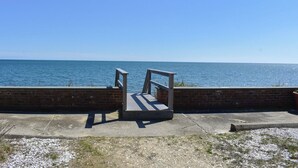 A concrete bench overlooking a body of water. - 1 bedroom cottage with ac, steps to the beach! (Dennis Port)