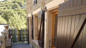 A stone building with a tiled walkway leading to a wooden door.