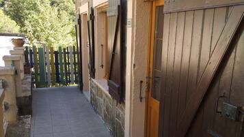 A stone building with a tiled walkway leading to a wooden door.