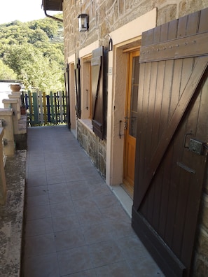 A stone building with a tiled walkway leading to a wooden door.