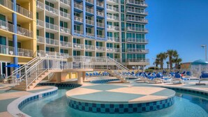A hotel with a pool area, multiple balconies, and a clear sky. - Avista Resort 823-1BR/1BA Oceanfront Condo in Ocean Drive (North Myrtle Beach)