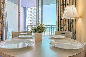 Une table à manger avec quatre assiettes blanches, une plante en pot et une lampe.