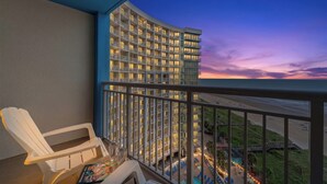 Un balcon donnant sur un immeuble d’hôtel et une plage.