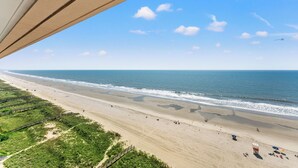 A beach with a wooden boardwalk, a sandy shore, and a clear sky. - Bahama Sands Luxury Villas PH6-3BR/3BA Oceanfront condo in Crescent Beach (North Myrtle Beach)