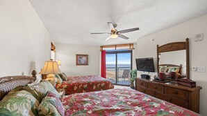 A hotel room with two beds, a ceiling fan, a TV, a dresser, and a balcony with a view. - Beachwalk Villas 808-2BR/2BA Condo in Cherry Grove (North Myrtle Beach)