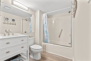 Features a sleek vanity, walk-in shower, and toilet.