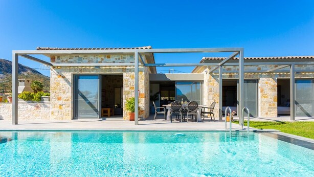 A modern poolside area with a clear pool, stone walls, and a covered seating area. - Villa Angelos - Three Bedroom Villa, Sleeps 6 (Ionian Islands)